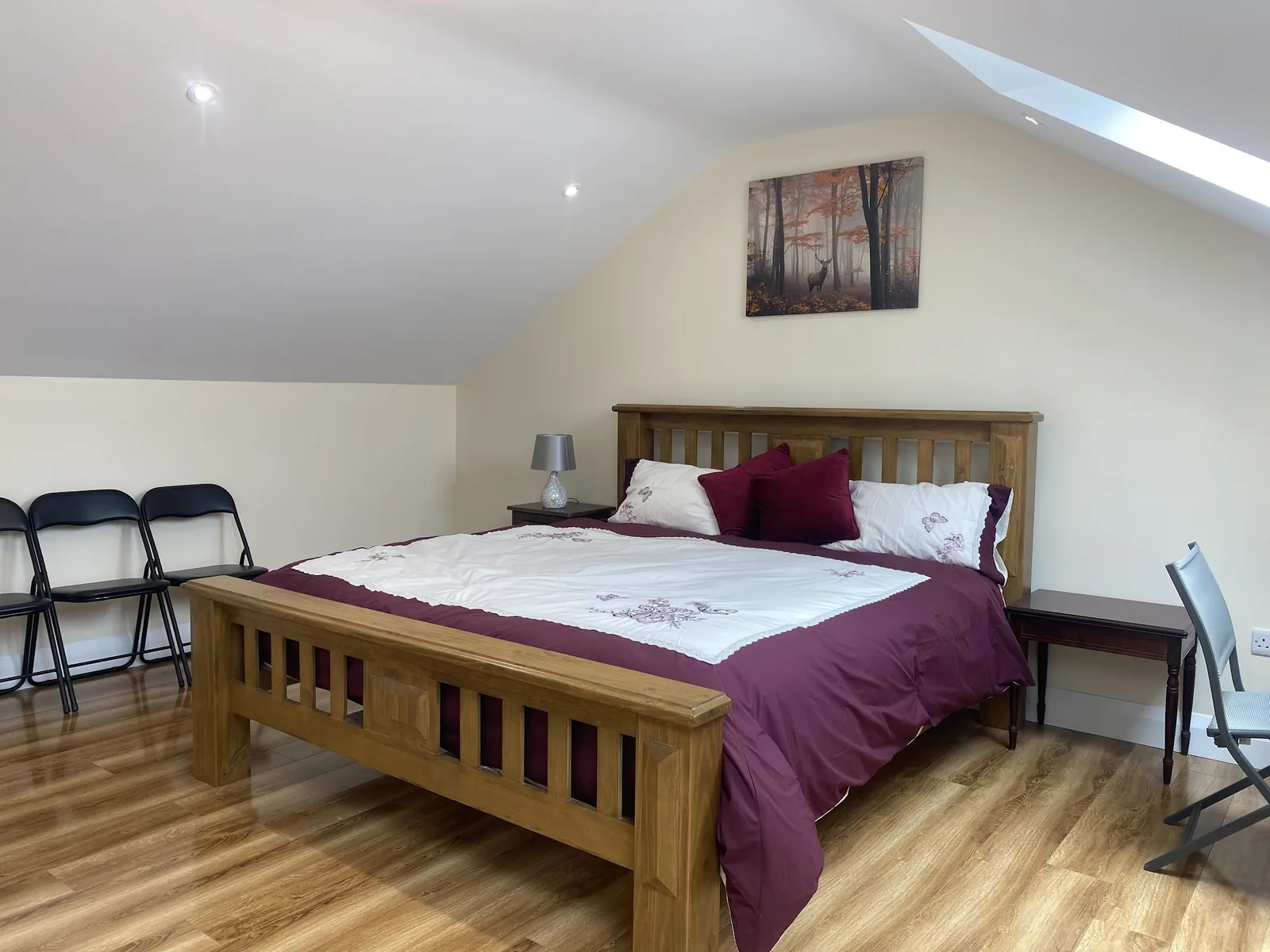 Solid oak attic bedroom with twin Velux skylights and burgundy linen