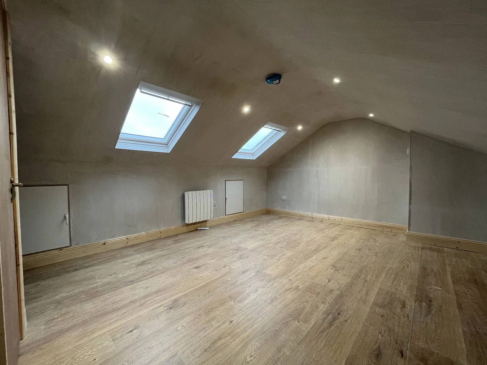 Attic conversion at plaster stage with twin Velux and engineered oak floor